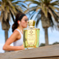 Beverly Hills Exclusive Extrait de Parfum by Unique’e Luxury with perfume bottle in a palm lined outdoor setting